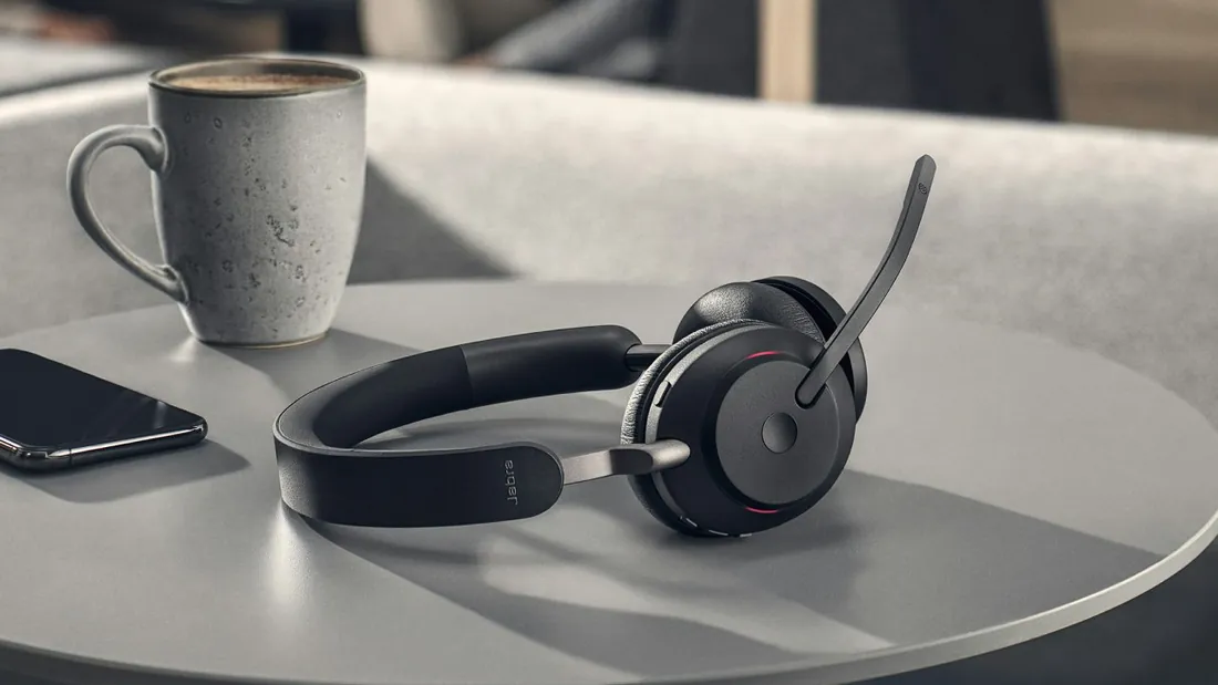 Jabra Evolve2 65 sobre una mesa junto a un café y un celular