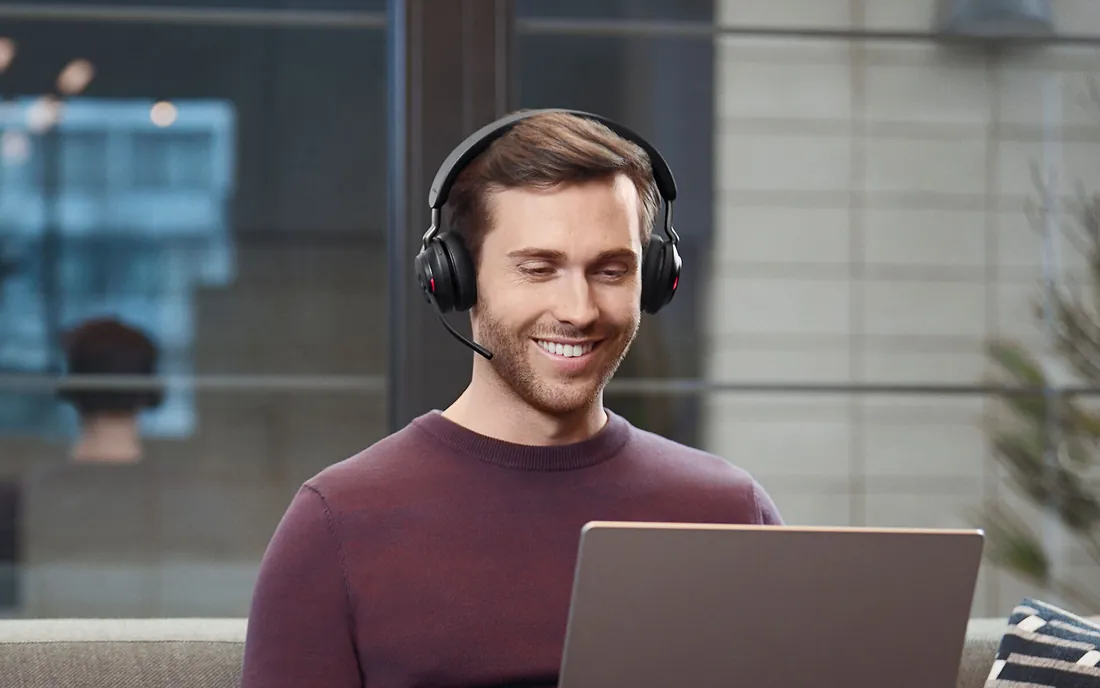 Persona trabajando con una notebook y el auricular Jabra Evolve2 65 puesto