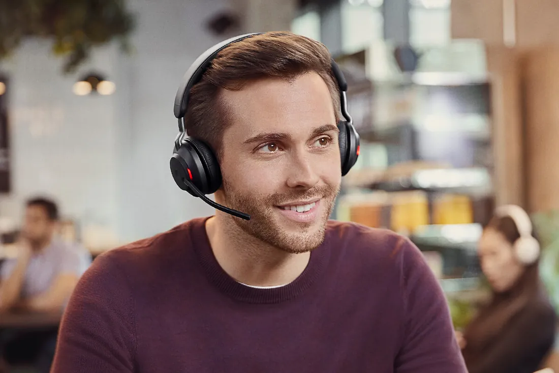 Hombre hablando por teléfono con el Jabra Evolve2 65 en un bar