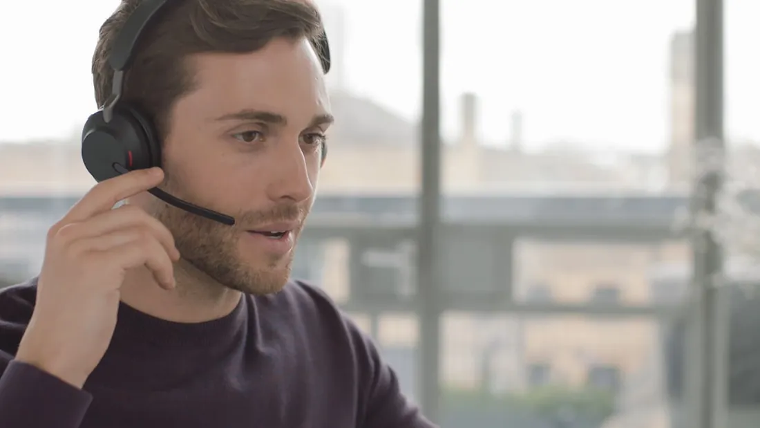 Hombre ajustando el micrófono del Jabra Evolve2 65